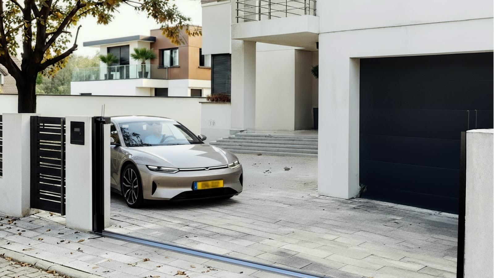 Silver car exiting a driveway through a HiddenGate sliding gate